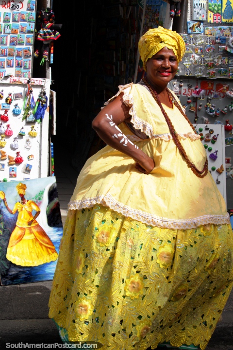 The African culture in Salvador is evident, woman in yellow and a painting also. (480x720px). Brazil, South America.