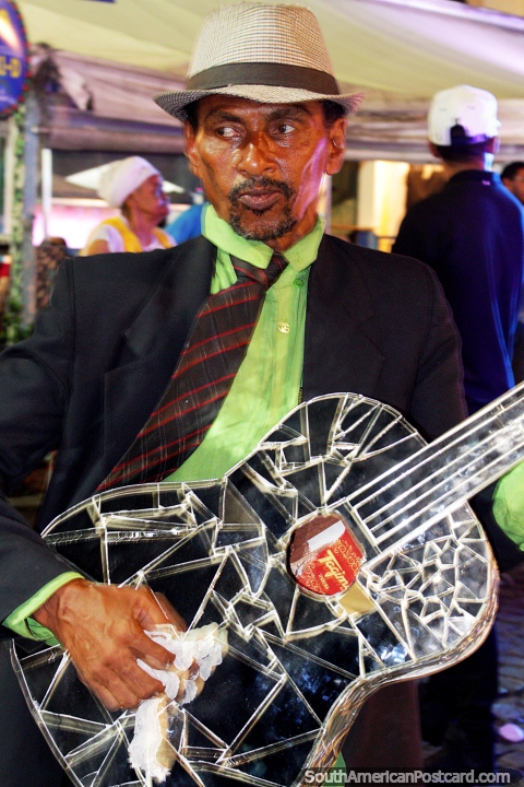 El hombre con la guitarra reflejada toca una meloda en el carnaval de Salvador. (480x720px). Brasil, Sudamerica.