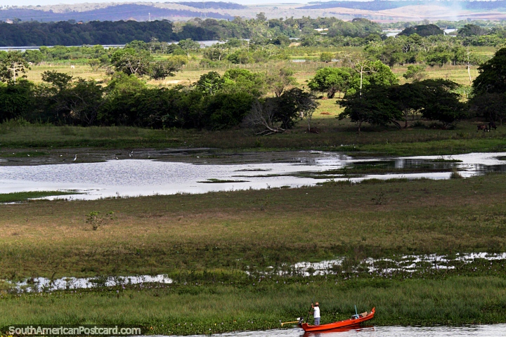 Hombre en una canoa de ro, pastizales distantes y colinas alrededor de Penedo. (720x480px). Brasil, Sudamerica.
