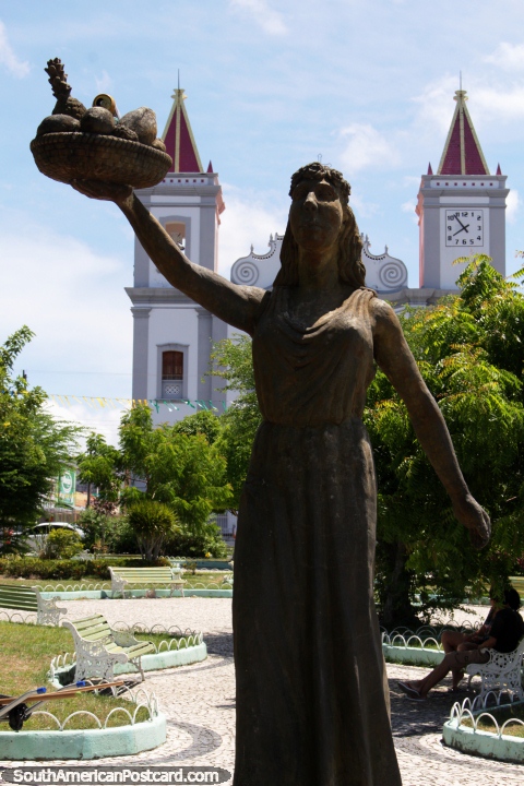 Woman holds up fruit - statue, the plaza and church of Neopolis. (480x720px). Brazil, South America.