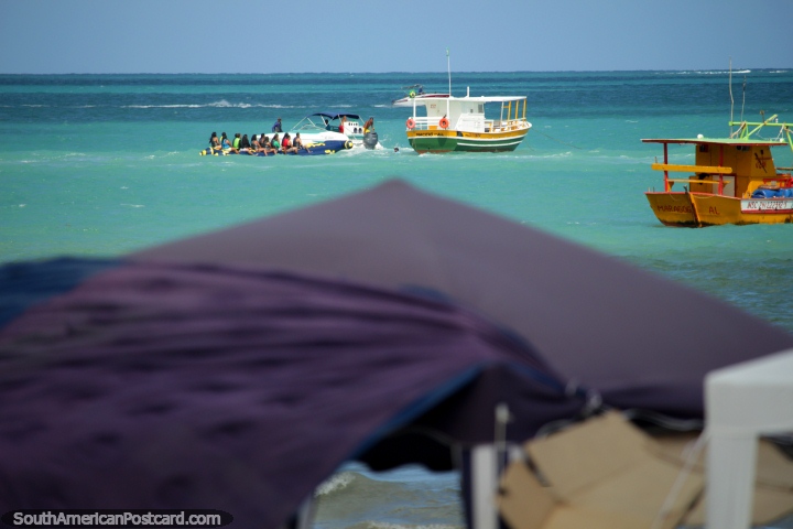 A crowd get towed out to sea on a banana boat in Maragogi, they are about to get wet! (720x480px). Brazil, South America.