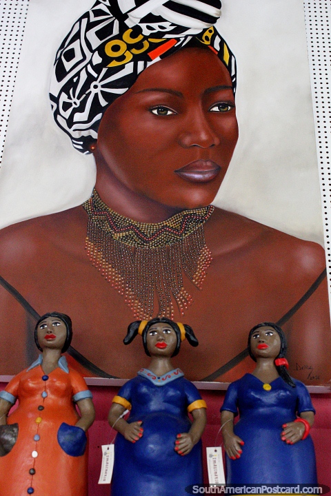 Painting of a woman with white head-scarf, 3 ceramic dolls in front, Olinda. (480x720px). Brazil, South America.