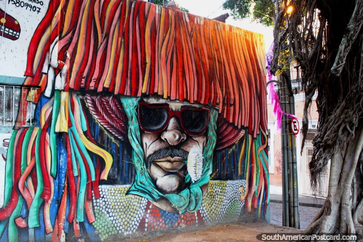Un hombre tiene su rostro enterrado bajo su sombrero y disfraz, arte callejero en Olinda. (720x480px). Brasil, Sudamerica.