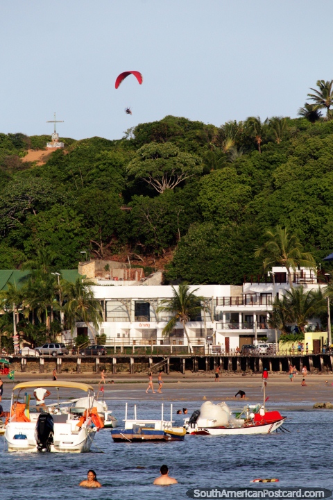 Pessoas em um papagaio de papel acima das colinas que contemplam do alto Praia de Pipa. (480x720px). Brasil, América do Sul.