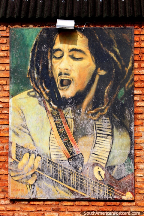 Bob Marley singing and playing guitar, a worn mural in Pipa. (480x720px). Brazil, South America.