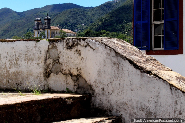 A distant church perched on a hill and mountains all around in Ouro Preto. (720x480px). Brazil, South America.