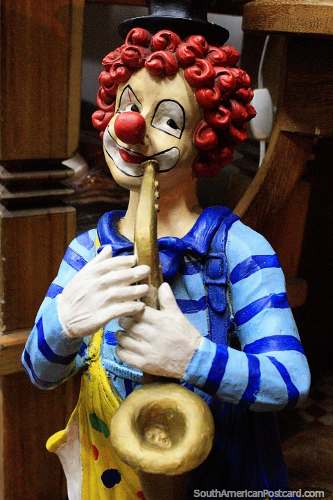 Clown with red hair and blue shirt plays saxophone, a figurine at a shop in Ouro Preto. (480x720px). Brazil, South America.