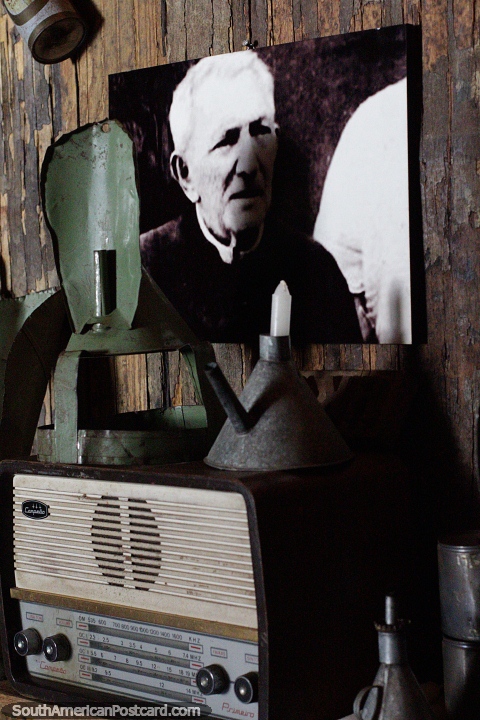 Foto de um homem em preto e branco e uma velha rádio, itens em monitor no museu de borracha em Rio Branco. (480x720px). Brasil, América do Sul.