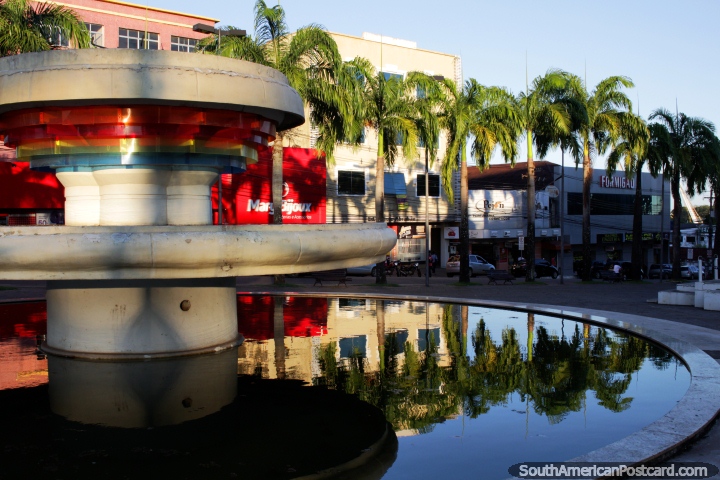 Palm trees reflect in the waters of the fountain at days end in Rio Branco. (720x480px). Brazil, South America.
