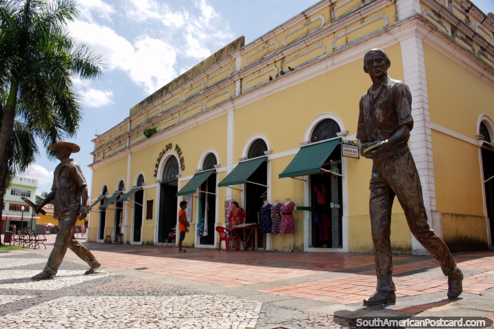 Mercado Velho (Mercado Viejo), edificio amarillo construido en 1929 en Rio Branco, 2 figuras de bronce caminando. (720x480px). Brasil, Sudamerica.