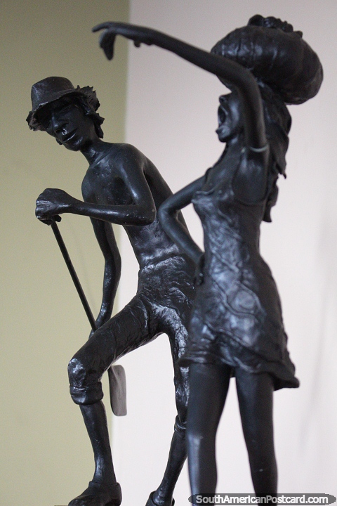 Escultura de bronze de homem e mulher, tem uma pá, tem um pacote na sua cabeça, museu em Porto Velho. (480x720px). Brasil, América do Sul.