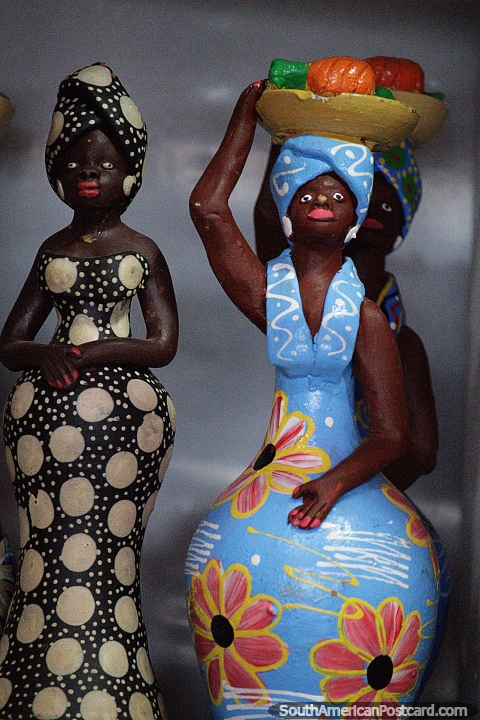 Mujer de azul con una fuente de frutas en la cabeza y una mujer en blanco y negro, figuras de cermica en Porto Velho. (480x720px). Brasil, Sudamerica.