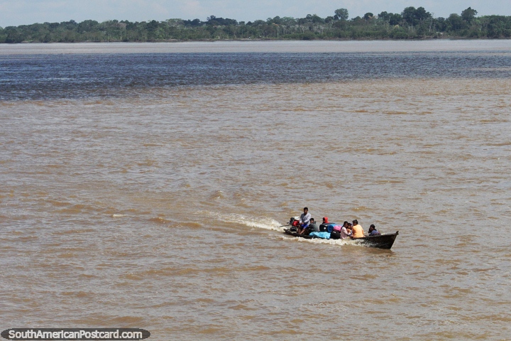 Passengers arrive at the port in Tabatinga in a small boat on a big river. (720x480px). Brazil, South America.