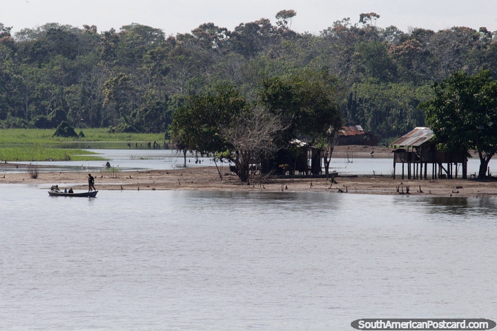 The journey on the Amazon River continues, stilt houses and people in a small boat. (720x480px). Brazil, South America.