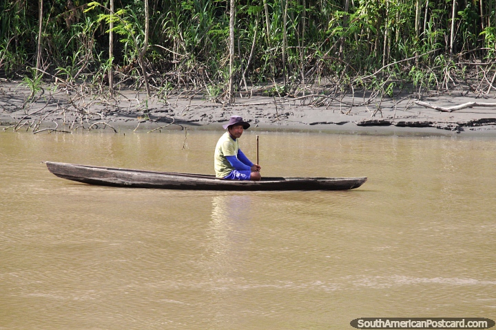 Indigenous man of the Amazon in a hand-carved wooden canoe. (720x480px). Brazil, South America.