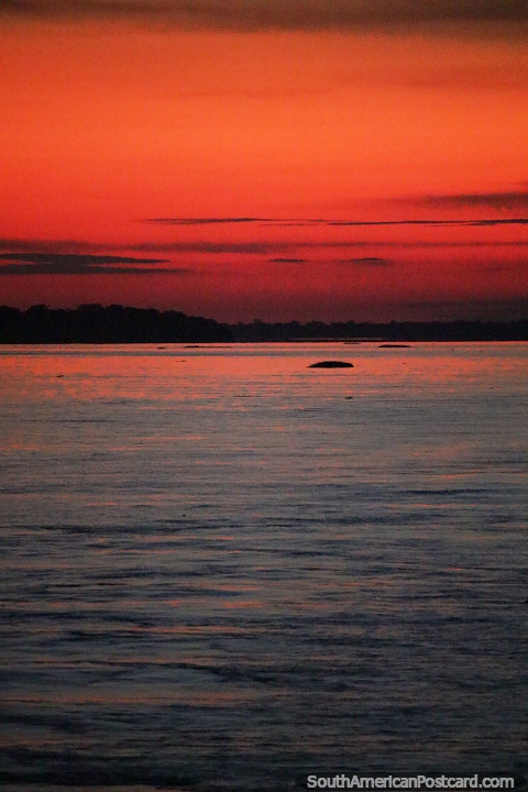 Por do sol laranja e vermelho brilhando sobre o rio Amazonas. (480x720px). Brasil, Amrica do Sul.