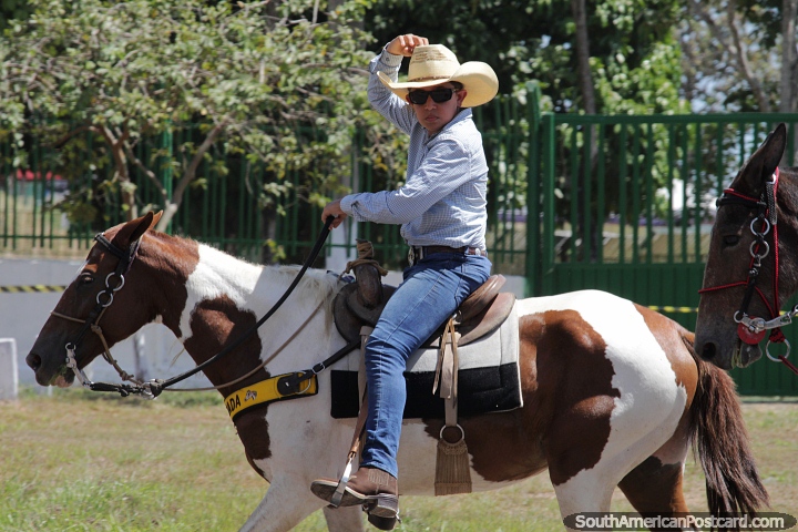 Young cowboy tips his hat as he rides his brown and white horse at the festival in Maraba. (720x480px). Brazil, South America.