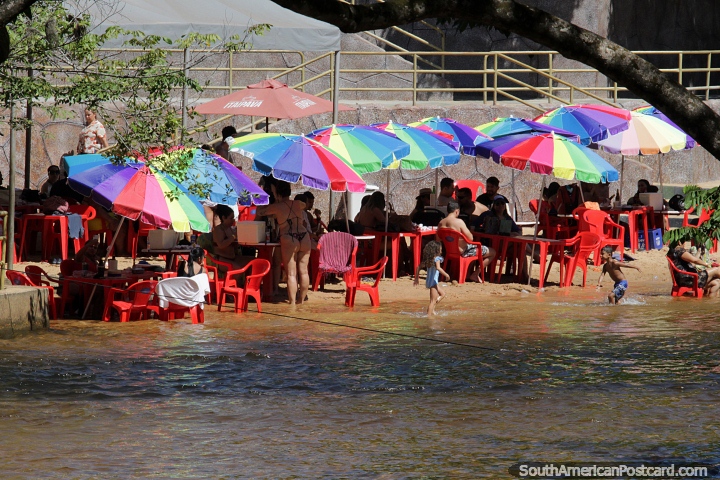 People enjoy the shade under colorful umbrellas beside the river at Itapecuru in Carolina. (720x480px). Brazil, South America.