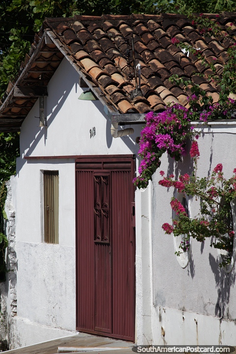 Techo de tejas rojas y flores, fachada de una casa blanca en Carolina. (480x720px). Brasil, Sudamerica.