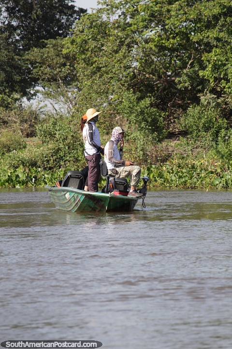 3 personas pescando desde un pequeo barco en el ro Paraguay en el Pantanal de Corumb. (480x720px). Brasil, Sudamerica.