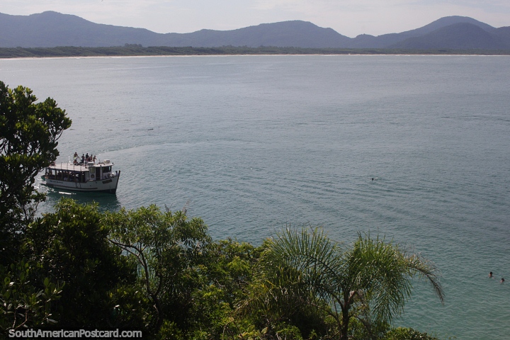 Boat passes along the coastline at Barra da Lagoa in Florianopolis. (720x480px). Brazil, South America.