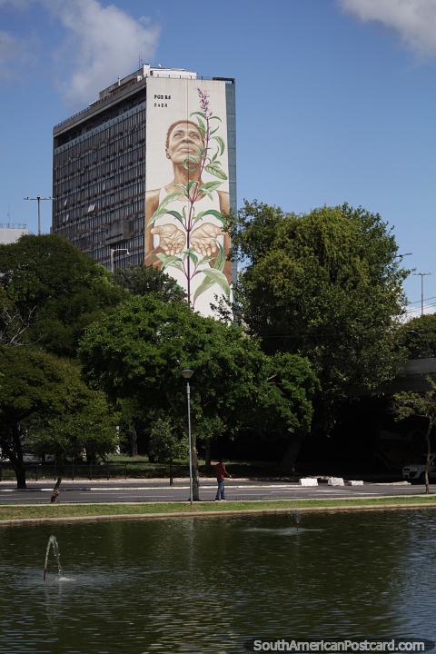 Woman raises the plant to grow, gigantic mural in Porto Alegre. (480x720px). Brazil, South America.