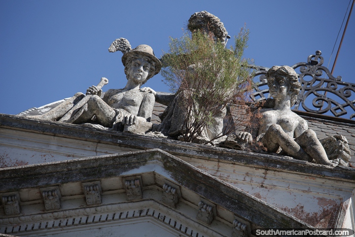 Ceramic figures peer down from an historic building top in Uruguaiana. (720x480px). Brazil, South America.