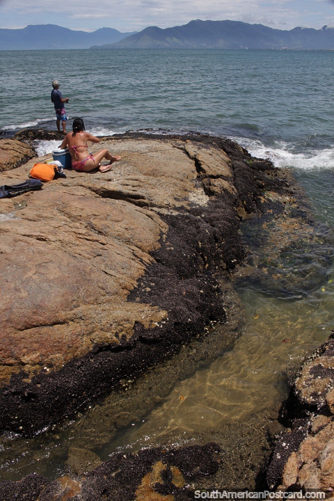 Pessoas pescando nas pedras de Caraguatatuba. (480x720px). Brasil, Amrica do Sul.