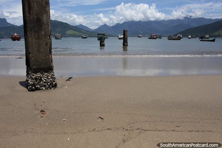 Antiguos pilones del muelle en la arena y el agua en la playa de Saco en Mangaratiba. (720x480px). Brasil, Sudamerica.
