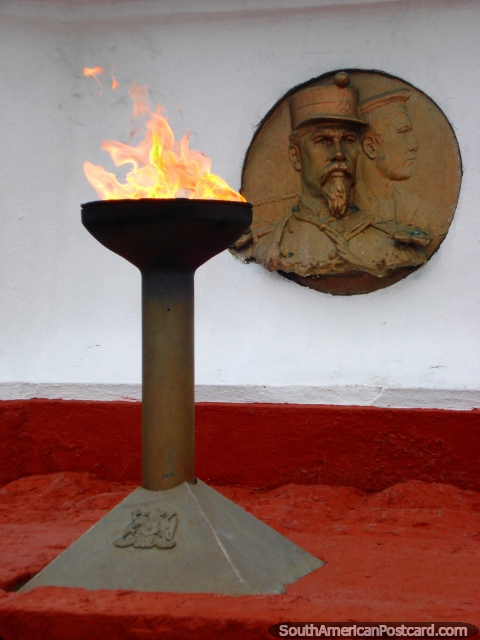 Uma chama e placa ornamental no p de uma esttua grande em Iquique. (480x640px). Chile, Amrica do Sul.