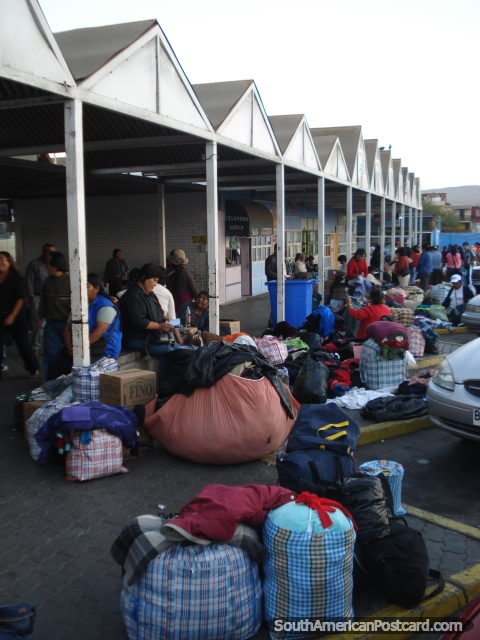 Pessoas peruanas que arrumam as suas mercadorias de roupa depois de uns dias que comerciam em Arica para atravessar atrás no Peru. (480x640px). Chile, América do Sul.