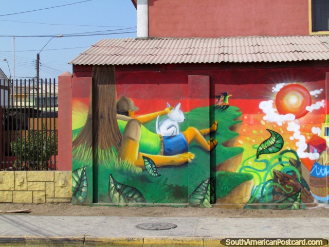 Man sits under a tree with his pet wall mural in Antofagasta. (640x480px). Chile, South America.