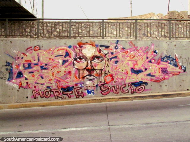 Face peers out of a pink graffiti wall under a bridge in La Serena. (640x480px). Chile, South America.