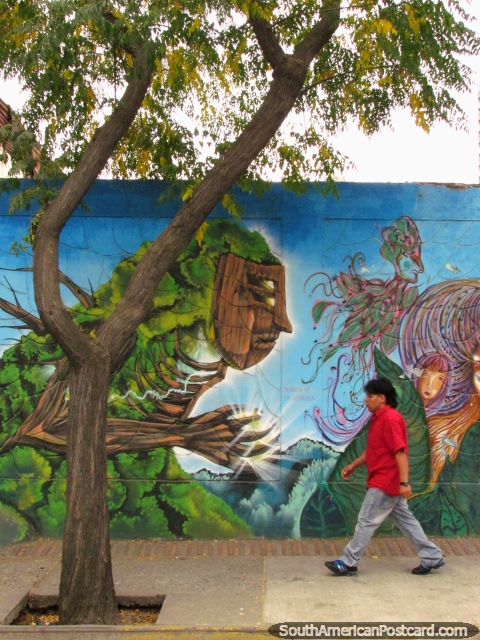 Los rboles estn vivos! El hombre anda por delante de una pintura mural de la calle en Barrio Brasil, Santiago. (480x640px). Chile, Sudamerica.
