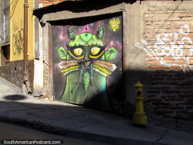 Um estrangeiro verde ou o marciano imaginam o mural em uma porta de ferro, parede de tijolos, hidrante de fogo, Valparaso. (640x480px). Chile, Amrica do Sul.