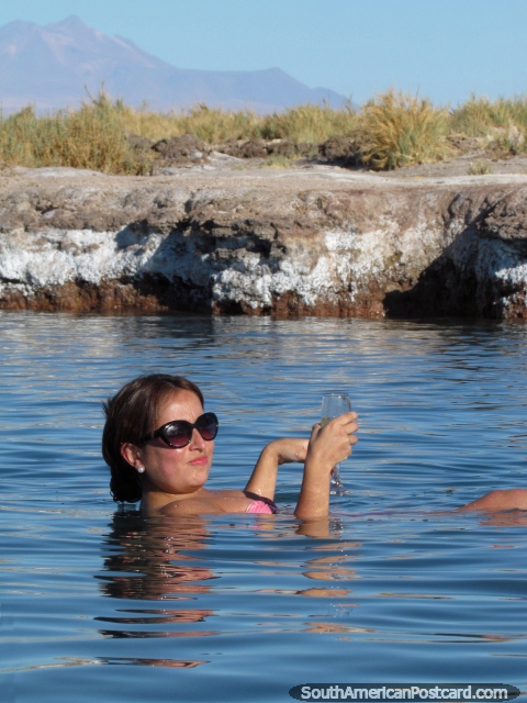 La mujer disfruta de una copa de vino mientras en el agua en la Laguna Cejar en San Pedro de Atacama. (480x640px). Chile, Sudamerica.