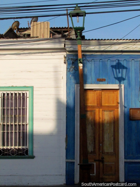 Casa azul, porta de madeira, iluminação de rua e sombra em Iquique. (480x640px). Chile, América do Sul.