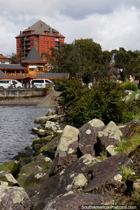 The grassy and rocky pier looking back towards buildings in Puerto Varas. (480x720px). Chile, South America.