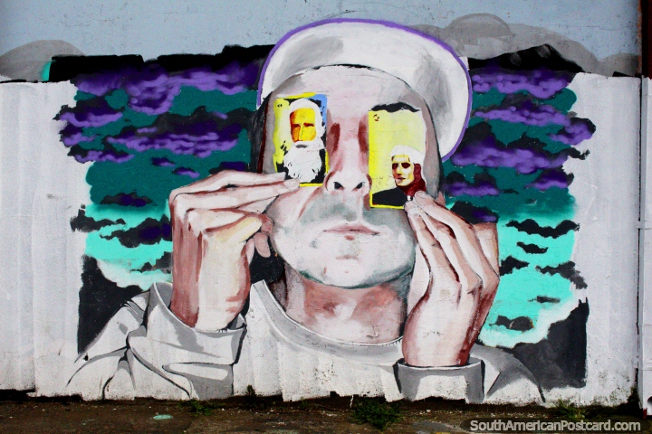Arte de rua em Osorno, o homem mantém 2 cartões em frente dos seus olhos. (720x480px). Chile, América do Sul.
