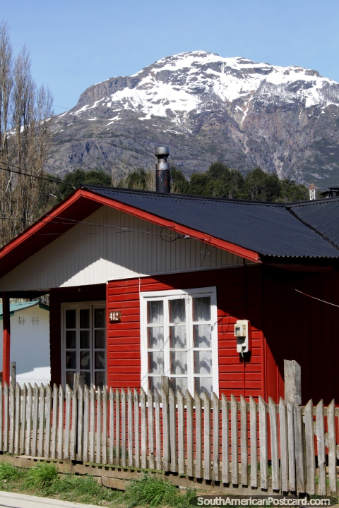 Casa vermelha de madeira em Futaleufu, as casas tm pilhas de lenha e chamins. (480x720px). Chile, Amrica do Sul.