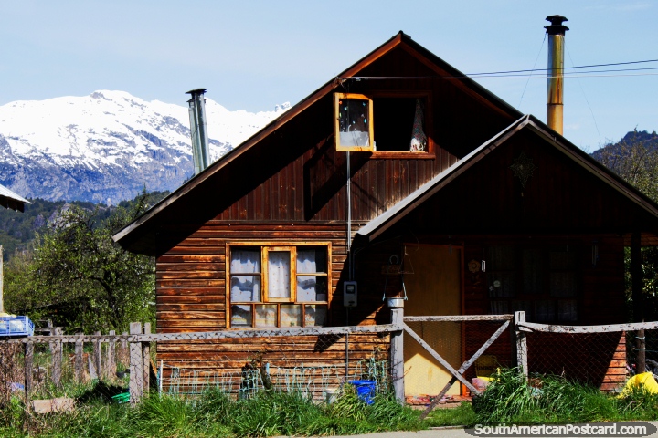 2 chimneys are better than one, wooden house in Futaleufu and a snowy backdrop. (720x480px). Chile, South America.