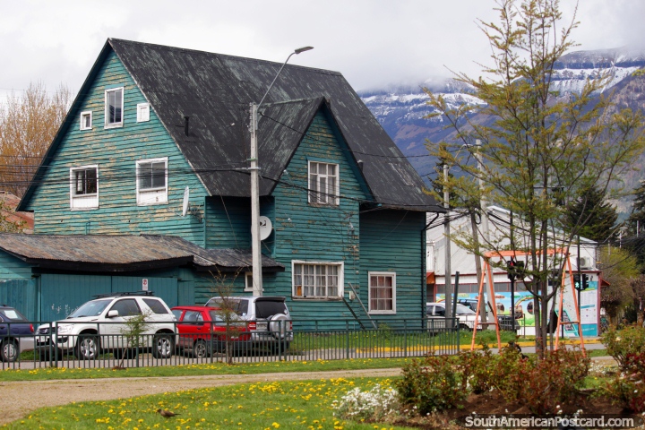 Enorme velha casa de madeira verde em uma esquina de rua em Coyhaique, destaca-se da multido. (720x480px). Chile, Amrica do Sul.