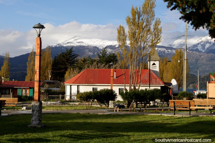 Techo rojo y la torre de la iglesia en Puerto Río Tranquilo, la plaza y las montañas cubiertas de nieve, hermosa! (720x480px). Chile, Sudamerica.