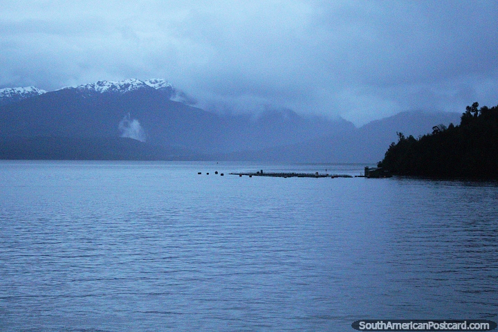 Blue haze upon the water, fjords and snow-capped mountains around Puerto Cisnes. (720x480px). Chile, South America.