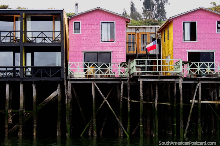 Casas rosa em pernas de pau com balces e ptios fora a gua em Castro. (720x480px). Chile, Amrica do Sul.