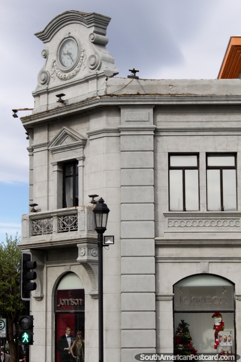 European architecture in Punta Arenas, building with a clock-face, a shop below. (480x720px). Chile, South America.