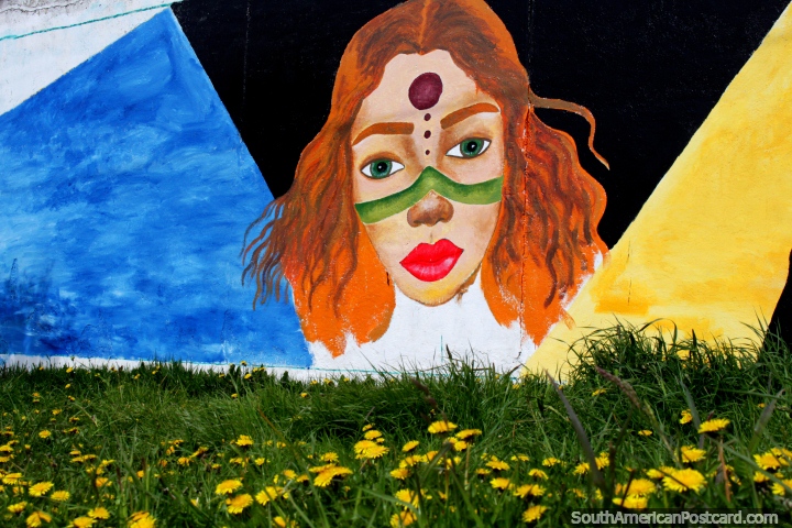 Street art in Punta Arenas, woman with green painted strip and dot on forehead, yellow daisies. (720x480px). Chile, South America.