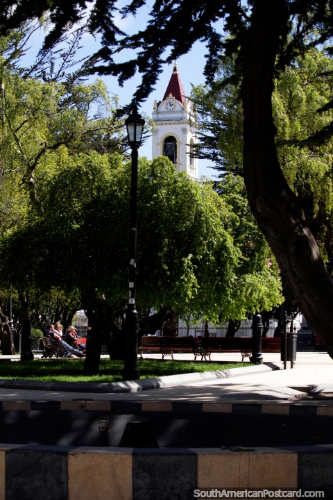 Vista a la catedral a través de la Plaza Muñoz Gamero, bonita y verde en Punta Arenas. (480x720px). Chile, Sudamerica.