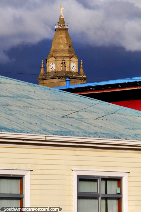 A torre de igreja distante contempla do alto a cidade de Punta Arenas. (480x720px). Chile, América do Sul.