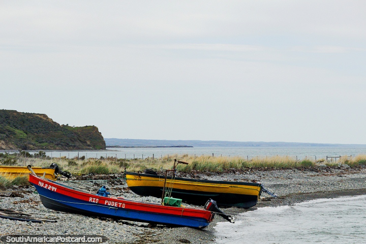 A pair of boats lay on a stony beach on the coast east of Porvenir. (720x480px). Chile, South America.